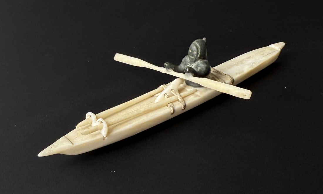 Josie Nulukie Alaskan Inuit Eskimo Ivory Kayaker: 4" by 2 1/2" by 7/8". Native made prior to 1972. This item cannot be shipped to Oregon, California, Hawaii, New York, New Jersey, Internationally, or any other state that prohibits.
