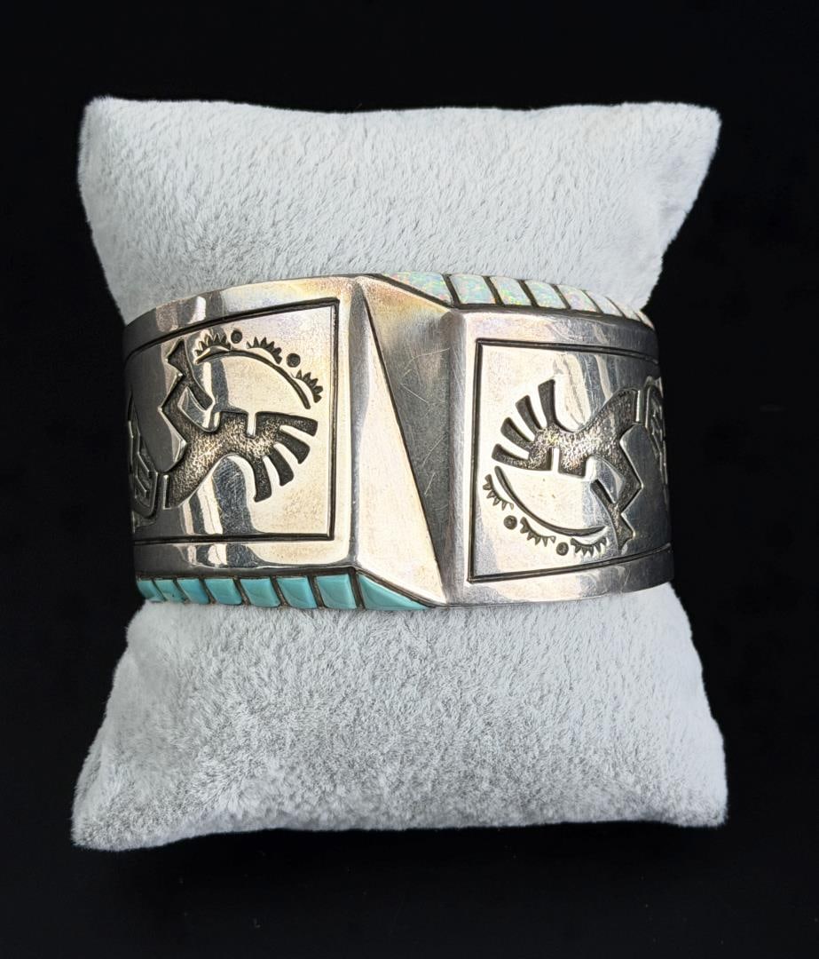 Leonard Jim Navajo Sterling Turquoise Bracelet: Nice design featuring 2 Kokopelli, Opal and Turquoise. 5 3/4" inner circumference. 79.1 grams.