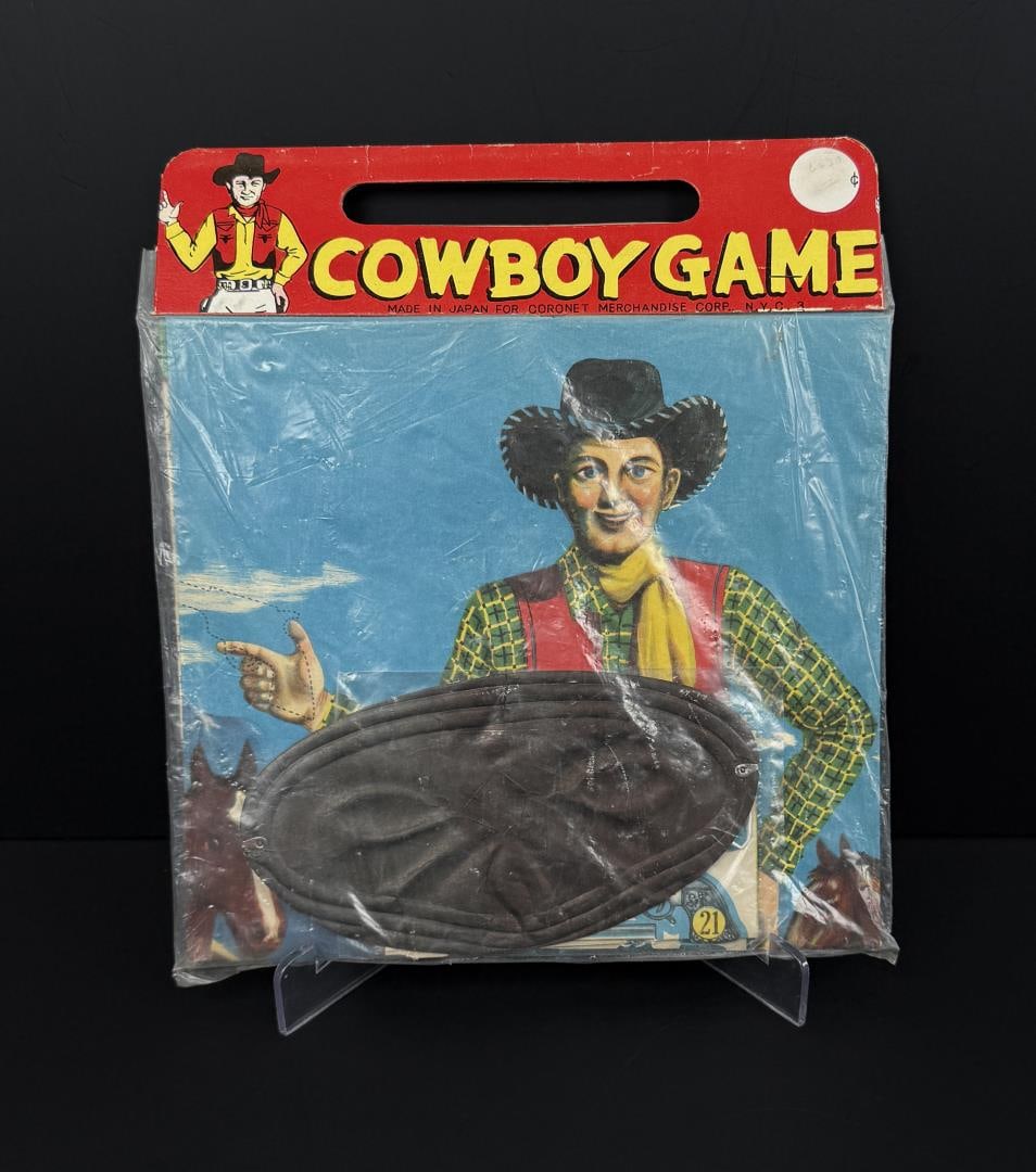 Mid Century Cowboy Game Coronet Merchandise: New in package. This game is similar to Pin the Tail on the Donkey, except players in the Cowboy Game pin a Six Shooter onto the cowboy's outstretched hand. The package is 9 7/8" by 8 1/2".