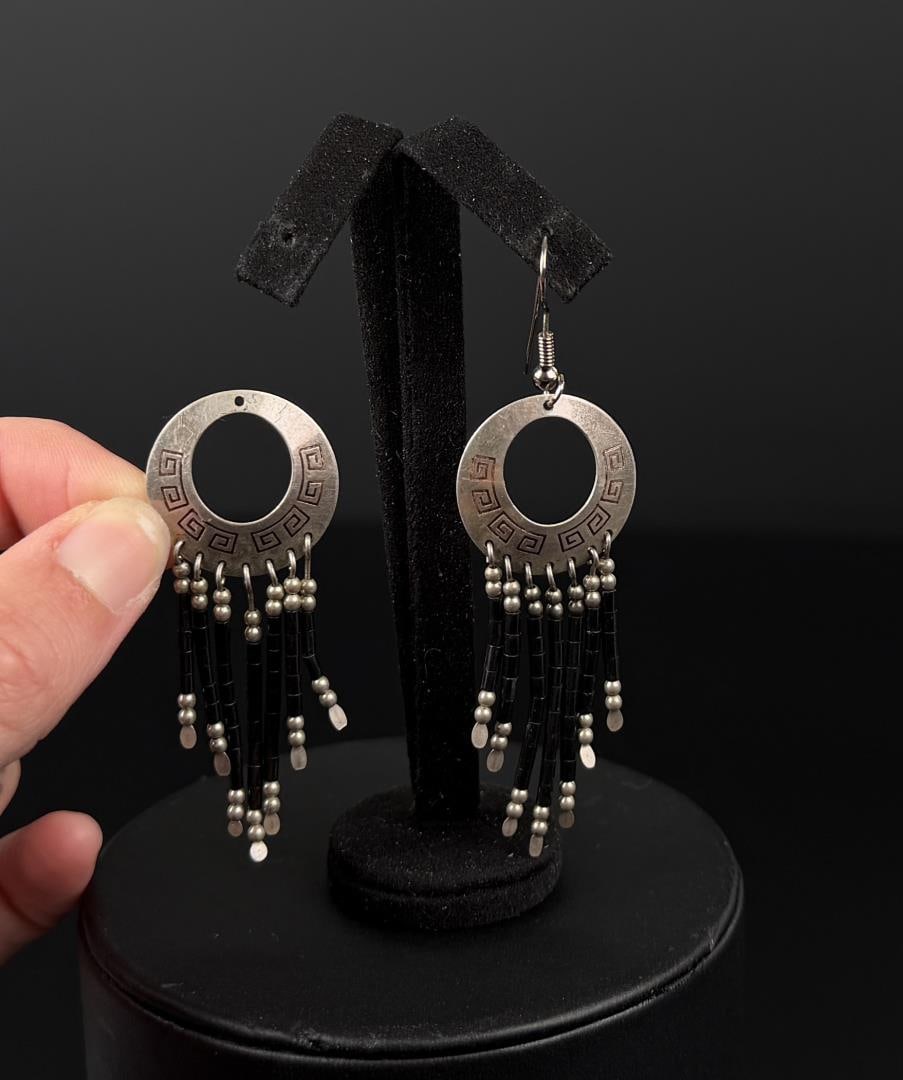 Navajo Sterling Silver Earrings: 2 7/8" by 1". 6.14 grams. One is missing the ear hook.