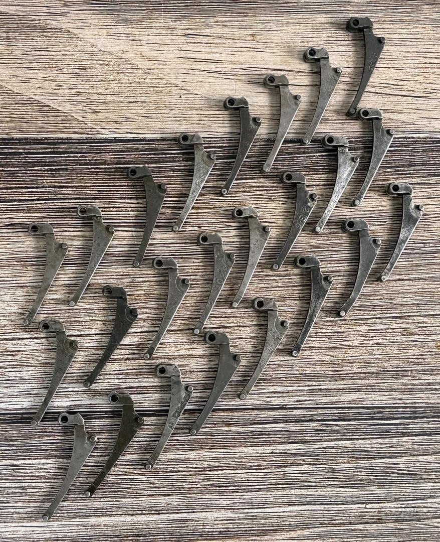M1 Garand Follower Arms: 24 total. 1 is marked "2" and "S", 1 is marked "2 102S", 1 is marked "S98", 1 is marked "2S9", 1 is marked "2S6", 1 is marked "2S1", 1 is marked "37", and 17 are unmarked.
