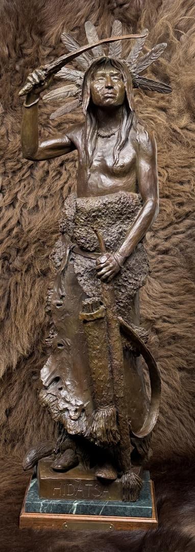 Richard Greeves Hidatsa Indian Bronze: Title is Hidatsa. 2004. 9" by 9" by 36". Edition 7/30. Richard Vernon Greeves (Born 1935) is active/lives in Wyoming, Missouri. Richard Greeves is known for Indian figure sculpture. A sculptor of monu