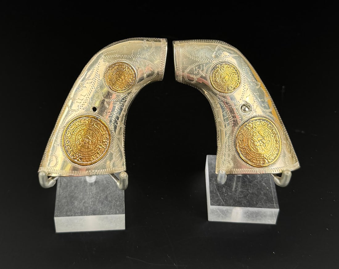 Mexico Sterling 10k Gold Colt Single Action Grips: Single Action Army. Mexican Calendar Pattern. Sterling Silver and 10k Gold. 91.96 grams total weight.