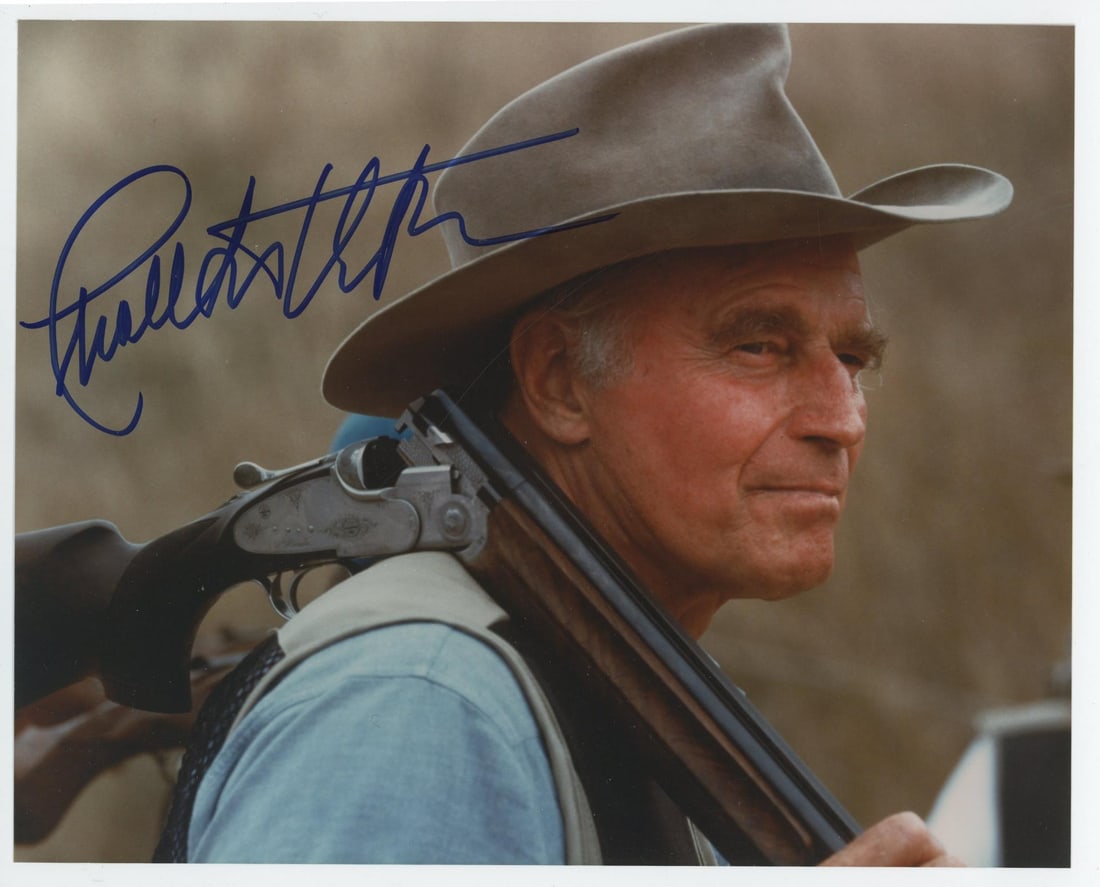 Charlton Heston Signed Photo: Charlton Heston signed this photograph of him wearing a western-style hat and carrying a shotgun. He was a prominent actor in Hollywood, with leading roles in the film Ben-Hur and Planet of the Apes. 