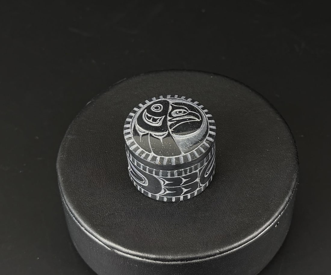 Denny Dixon Haida Miniature Argillite Box: 1 1/8" diameter, 3/4". Denny Dixon Born 1944 Skidegate oh Haida Gwaii, British Columbia. Known for: Argillite poles, boxes, pendants and broaches. Denny is a member of the Eagle clan. He works primari