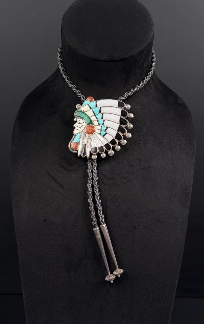 Ralph Quam Zuni Inlaid Sterling Bolo Tie: Stunning design of a chief in headdress on sterling silver. Museum quality. Measures 21 1/4" long. Slide is 2 3/4" wide. 60.75 grams