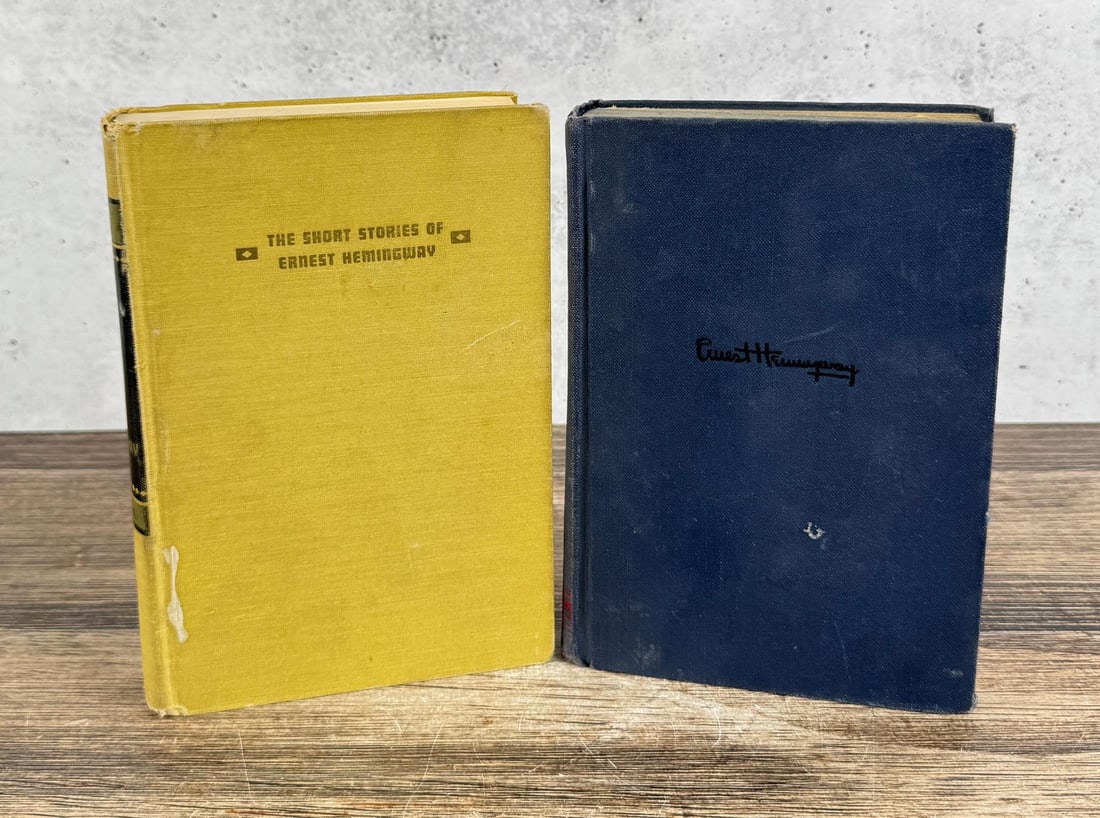 Pair of Ernest Hemingway Books: Yellow volume is The Short Stories, published by The New York Press. The blue volume is For Who The Bell Tolls, stamped with Hemingway's facsimile signature on the cover. Published by Charles