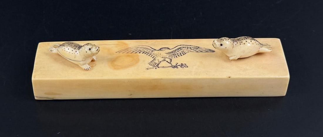 Alaskan Inuit Eskimo Ivory Scrimshaw Carving: Seals with Scrimshaw Federal Eagle. 6 1/8" by 1 1/2" by 1 1/4". This item cannot be shipped to Oregon, California, Hawaii, New York, New Jersey, Internationally, or any other state that prohibits.