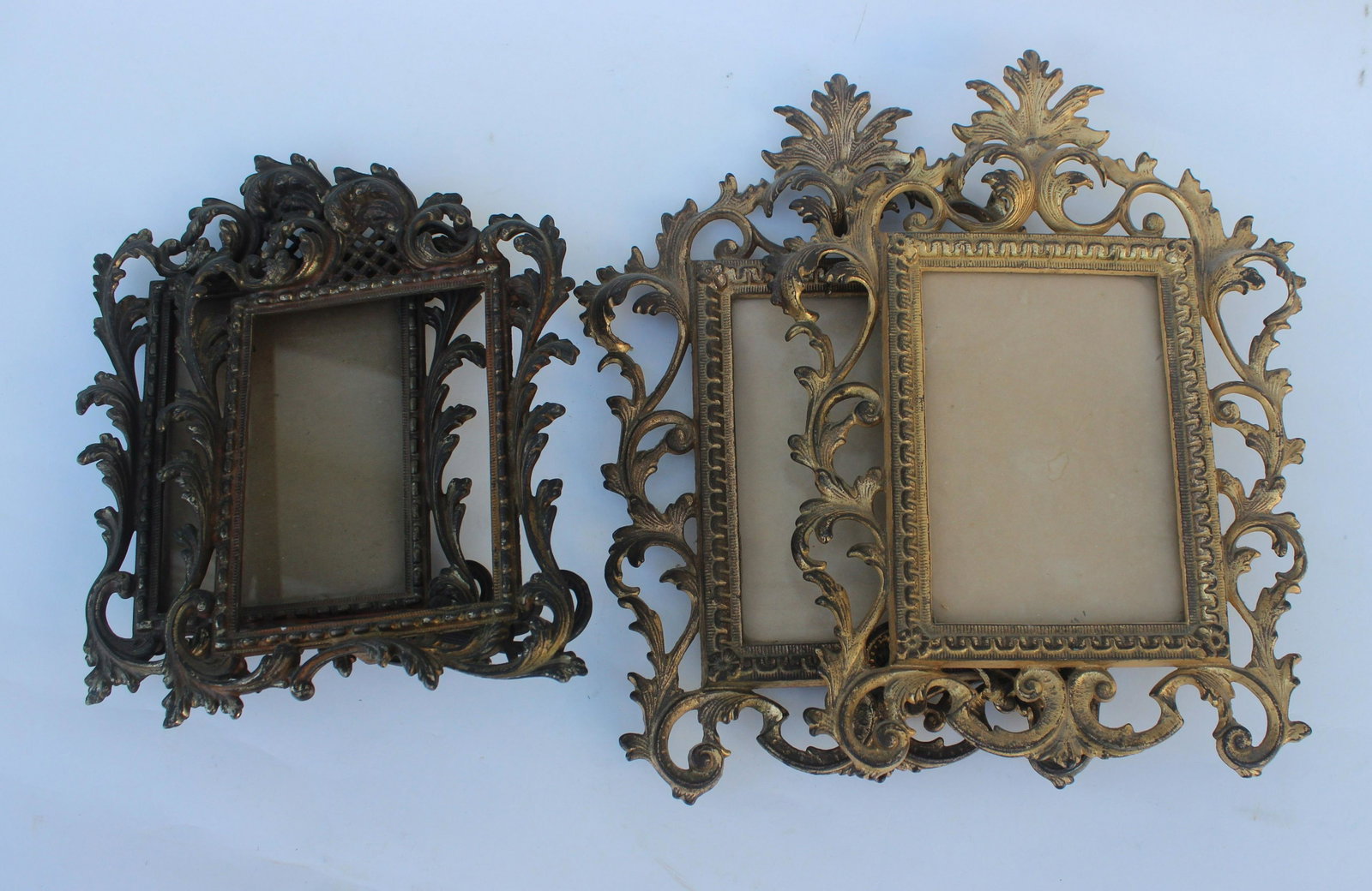 LOT OF 4 ANTIQUE BRASS FRAMES: 2 pairs of matching filigree heavy brass frames w/fold-out stand. Size 5.5" x 4 & 6" x 4"