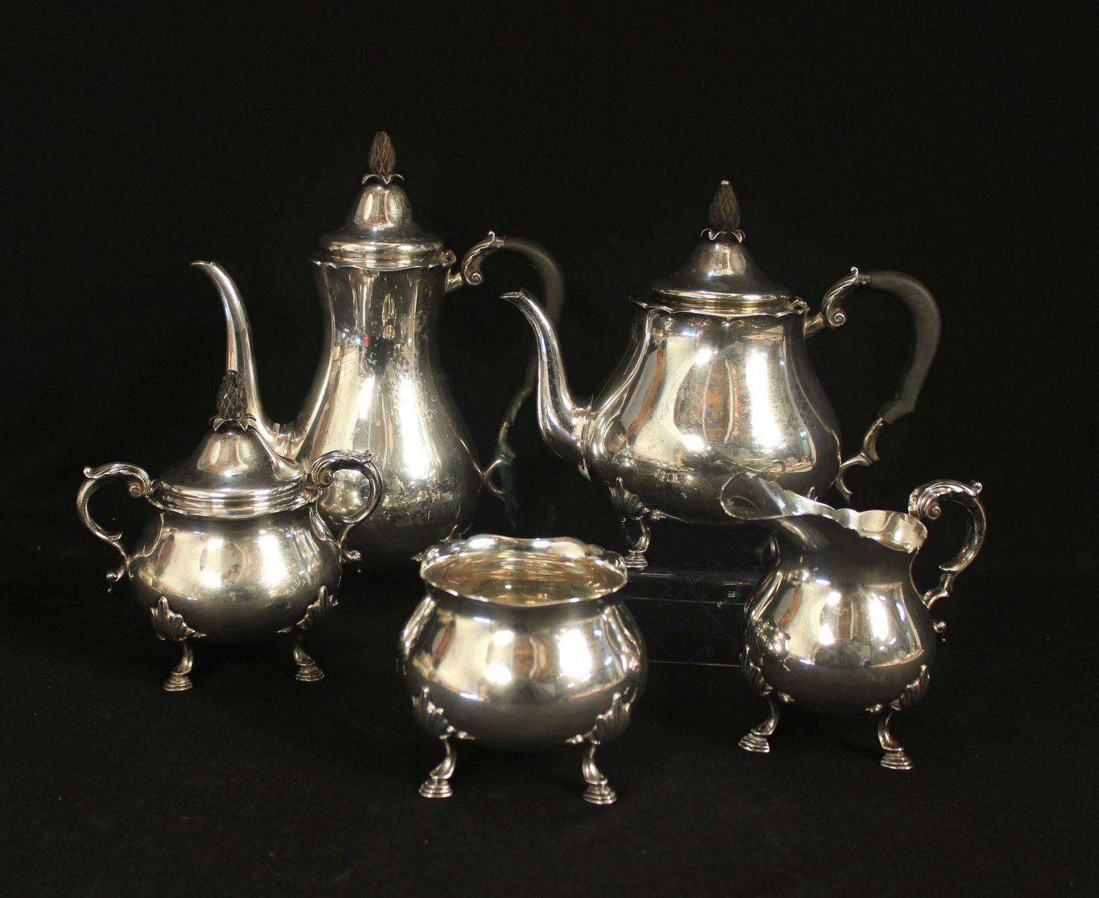 5 -PIECE STERLING SILVER TEA & COFFEE SET: Sold by Shreve, Crump & Low Co. made by Worden-Munnis Co. New York circa 1940's. This set consist of tea pot, coffee pot, sugar bowl, creamer & waste bowl. Footed set with wood handles & finials. Weig