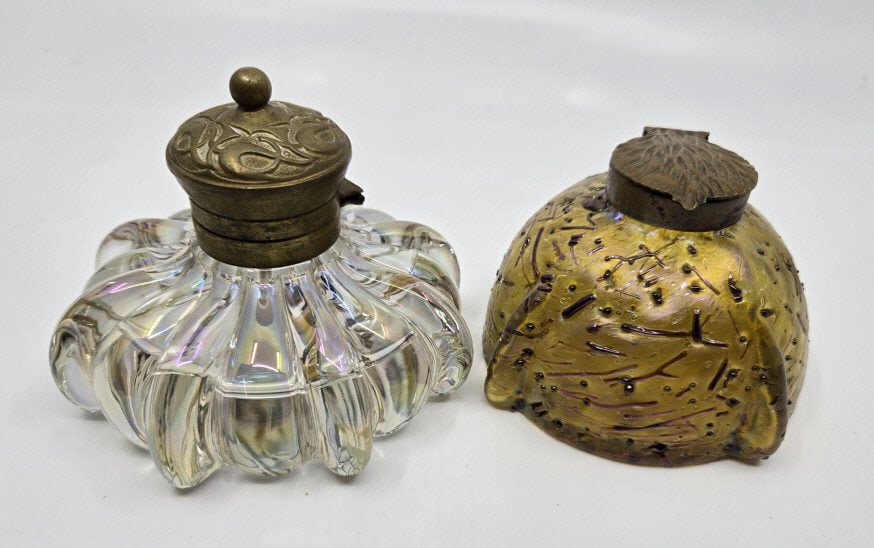 Two Art Glass Inkwells: Two Art Glass Inkwells. (1) Loetz opalescent with copper top. (1) Clear with ribbed sides & brass Art Nouveau top