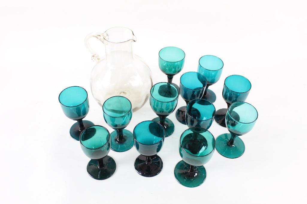 Blue Mid-century Modern Wine Glass Set with Pitcher: Lovely set of twelve blue/ green mid-century modern wine goblets with a clear pitcher that pairs nicely with them. The pitcher was hand blown and the glasses all slightly vary in size and color whi