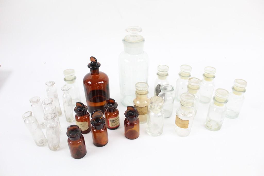 Lot of 24 Small Antique Brown & Glass Vials/Bottles: Lot of 24 Small Brown and Clear Glass Vials and Bottles. This lot includes 24 glass medicine and spice vials/small bottles of varying sizes and colors, most of which include tops and labels. The dimen