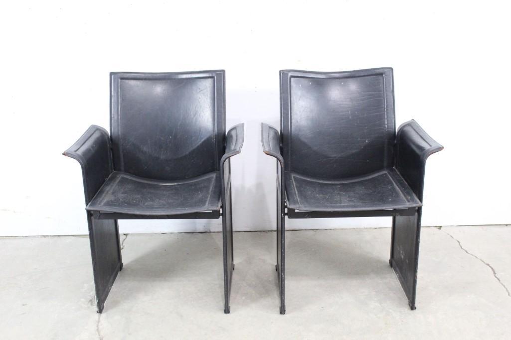 Pair of Wrapped Black Leather Postmodern Italian Chairs: Pair of black Postmodern 70s - 80s leather theater-style chairs. Leather is completely fitted over metal frame in a way that gives the appearance of wood or even single-pour resin from afarâ€”a m