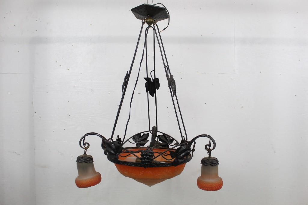Orange Glass Chandelier, Iron Nouveau, Daum Nancy Style: Orange Tinted Glass Chandelier, Iron Nouveau, Daum Nancy Style, featuring a leaf & grape metal ornament. This piece would compliment a dining room or foyer area with warm lighting. The dimensions are 