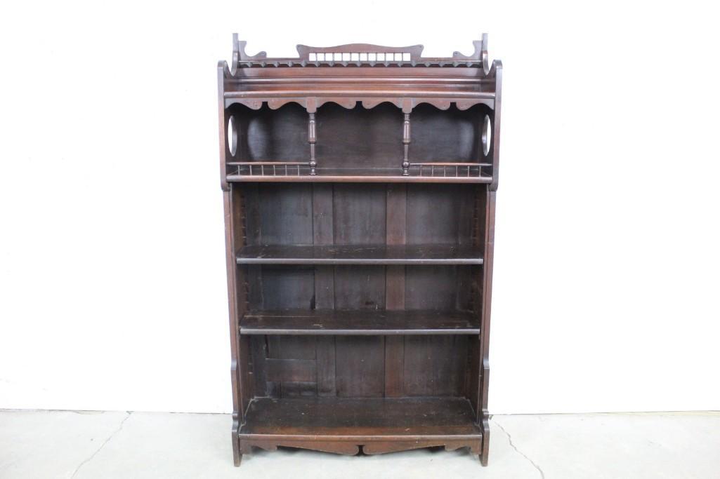 Antique Victorian Bookcase with Gingerbread Details: Ornate Gothic dark wooden 4 tiered shelves. These lovely shelves would be the perfect place to store trinkets, books, or treasures. It has lovely details. The dimensions are 61in h x 36in w x 12.5in d