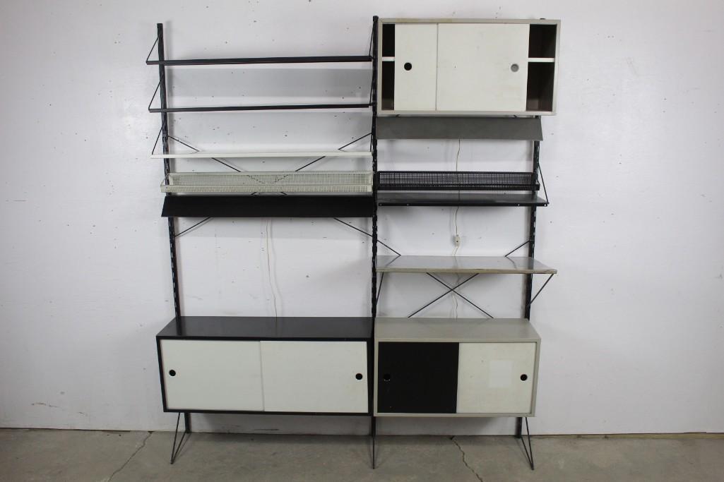Pilastro Mid-Century Modern Metal Wall Shelving Unit: Pilastro Mid-Century Large Metal Cabinet Wall Unit. Its color is black, white, and gray. Has 2 attached light fixtures, racks, 3 cabinets w/ doors, and some attached baskets. The heights of cabinets, 