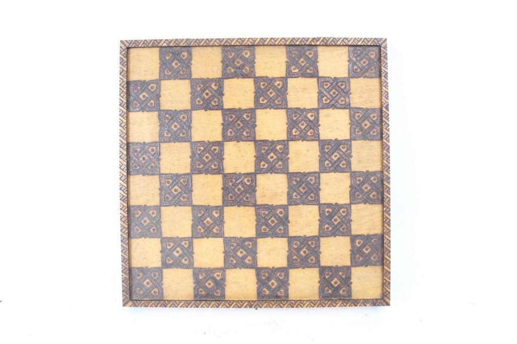 Mid-century Folk Art Hand-Carved Burned Wood Chess Set: A hand-carved wood chess set from the Mid-century era, with details of each piece etched and also burned into the wood, creating a striking contrast of blonde wood with dark brown. Gameboard squares f