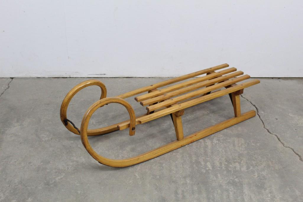 Curved Wooden Bentwood Sled w/ Metal Straps & Hardware: Curved Wooden Sled w/ Metal Straps & Metal Hardware. Sled has a whimsical look and two rails. The wood has a shiny patina. Bring it out in the cold of winter, hang it by the window with the finest vie