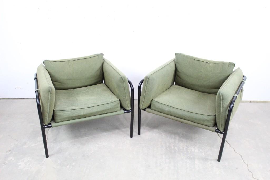 Pair of Modern Arm Chairs w/ Army Green Cushions: Pair of Modern Arm Chairs w/ Army Green Cushions. Seat, back, and arm cushion sit on a black metal frame and are secured to the frame with snap button straps. The seat cushion sits on a canvas green b