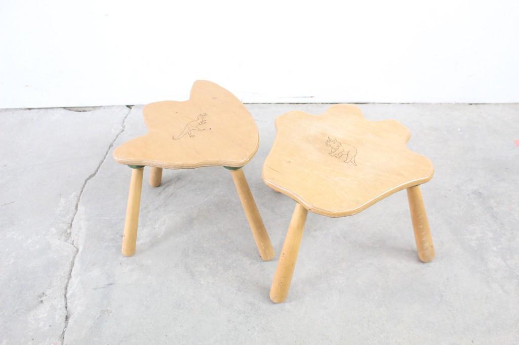 Pair of Children's Wood Dinosaur Footprint Foot Stools: Pair of children's wooden foot stools in the shape of dinosaur footprints, with images of each speciesâ€”Tyranosaurus Rex and Triceratopsâ€”etched into the tops. Made by "Footstools"â€”