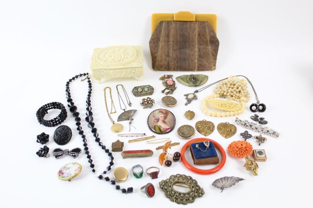 Lot of Costume Jewelry, Bakelite Purse,Nouveau, Pins: Lot of jewelry & costume jewelry, featuring a reptile skin purse, jewelry box, pins, charms & necklaces. A lovely collection that adds flair to any style. Dimensions range .5 in h to 6 in h. Condition