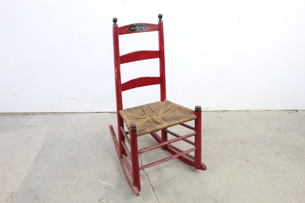 Red Painted Country Folk Art Wooden Rocking Chair: Red Painted Country Wooden Rocking Chair, with rope seat and hand painted floral decoration on the top rail. This very charming piece would look wonderful on your farmhouse porch, where it may be clai