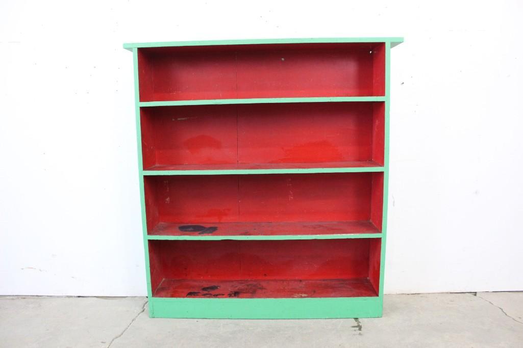 Painted Bright Green Wooden Boockase with Red Shelves: Painted bright green wooden bookcase with red shelves. Features "Ford" writing on the top shelf, as well as paint loss & wear throughout. This piece would be a great addition to a kitchen space. Dime