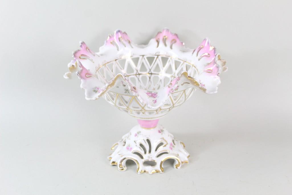 Antique KPM German Porcelain Pierced Pink Display Bowl: Antique KPM German Porcelain Pierced Pink Display Bowl. Pink and white with gilt details, the pierced porcelain bowl has a ruffled rim, and stands on a pedestal. Marked on the base KPM with a sceptre,