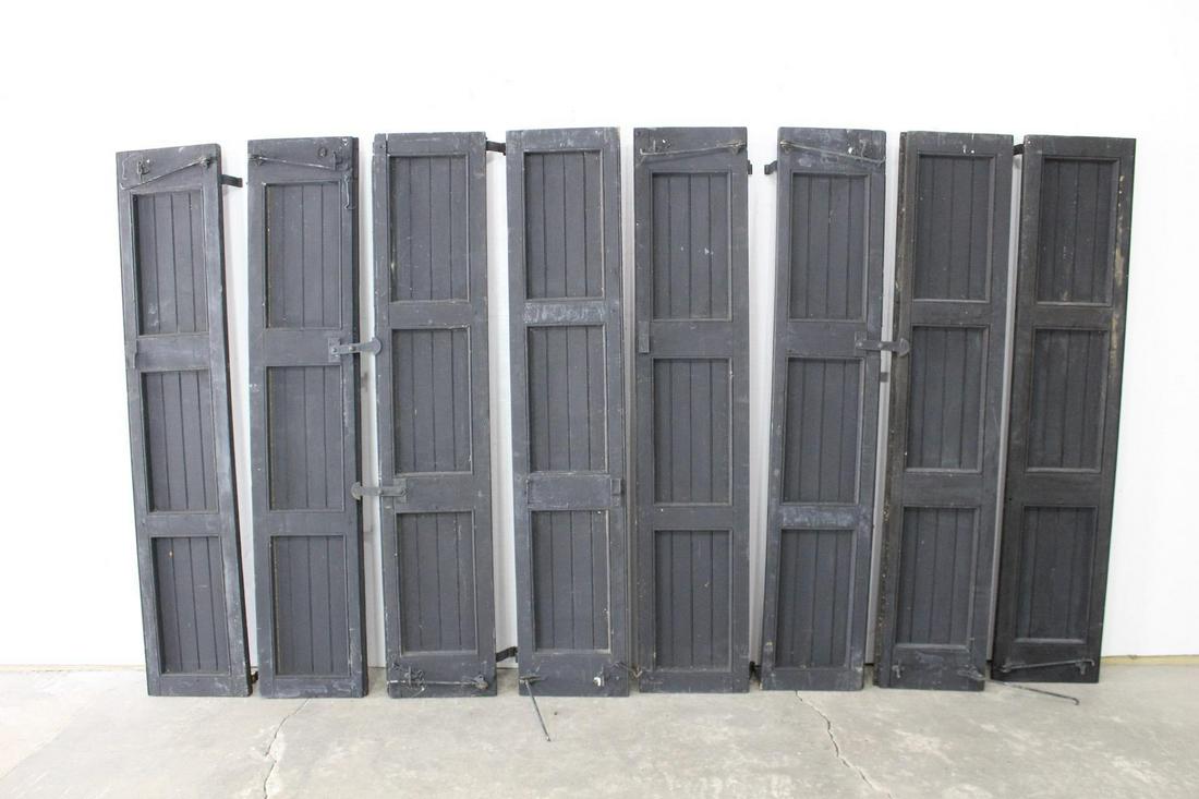 Set of 8 Antique Exterior Storm Shutters w/Wrought Iron: Set of eight antique exterior storm shutters painted black with wrought iron hardware. Paint is worn with a heavy patina exposing wood in some places. These shutters were part of Ezra Fitch’s childh