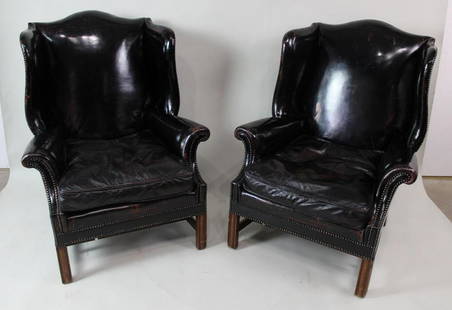 Pair of Black Patent Leather Studded Wingback Armchairs: Pair of Black Patent Leather Studded Wingback Armchairs. This is a sophisticated pair of patent leather, wingback armchairs. The curved frame of the chair is articulated by metal studs. Both chairs