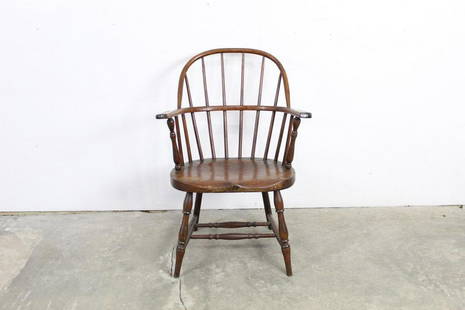Rounded Turned Wooden Windsor Barrel Arm Dining Chair: Rounded Turned Wooden Windsor Barrel Arm Dining Chair. This is a handsome windsor chair with vertical back slats, armrests, and turned wooden legs. It is made of a darker wood with a beautiful grain.