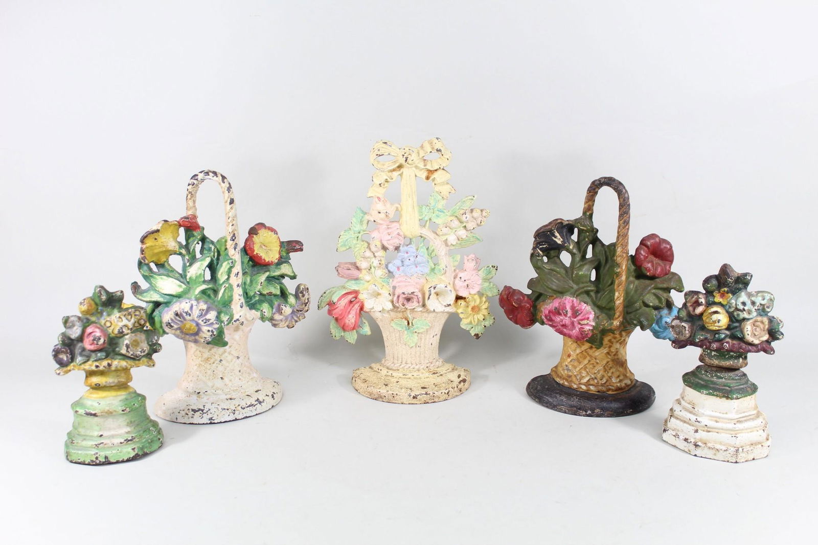 5 Cast Iron Color Painted Flower Bouquet Doorstops: Lot of 5 Cast Iron Hand-Painted Flower Bouquet Doorstops. This is a charming set of 5 cast iron flower bouquet doorstops. They all have different designs and are painted in various colors. They all ha