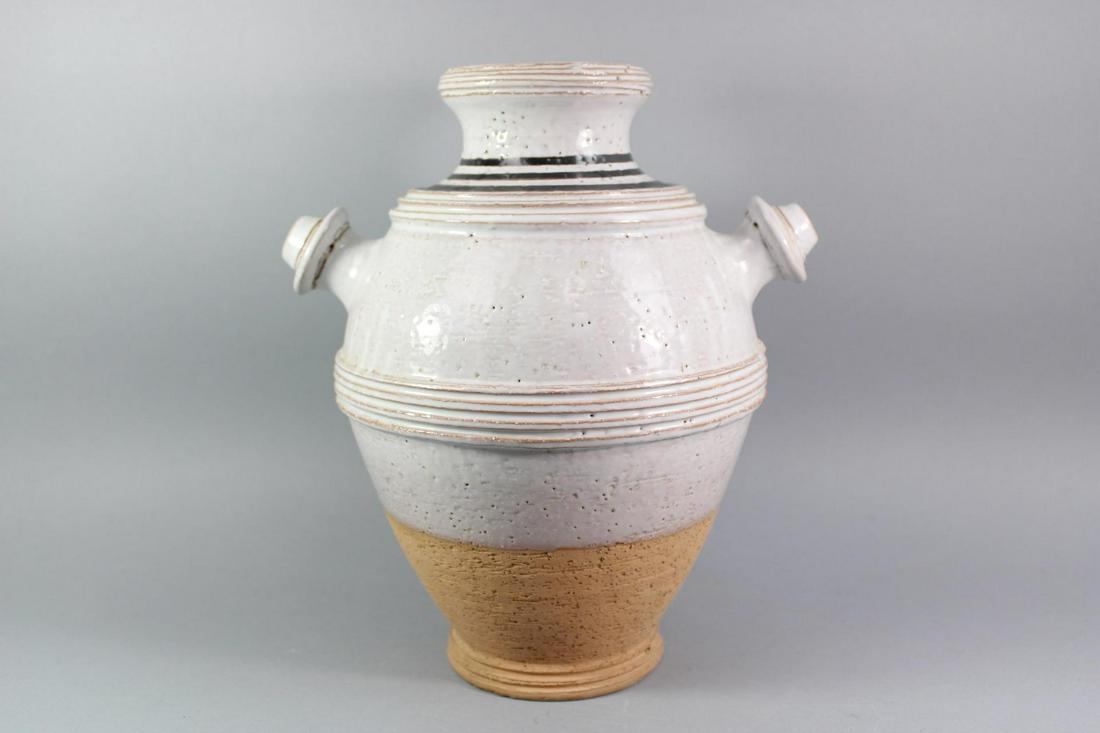 Mid Century Modern Natural Handled Pottery Vase by Bitossi, Italy: Mid Century Modern Natural Two-Handled Vase by Bitossi, Italy. This natural colored pottery vase has a partial paper label on the base. We attribute this to Bitossi.Dimensions are 11.75in h x 9.75 in