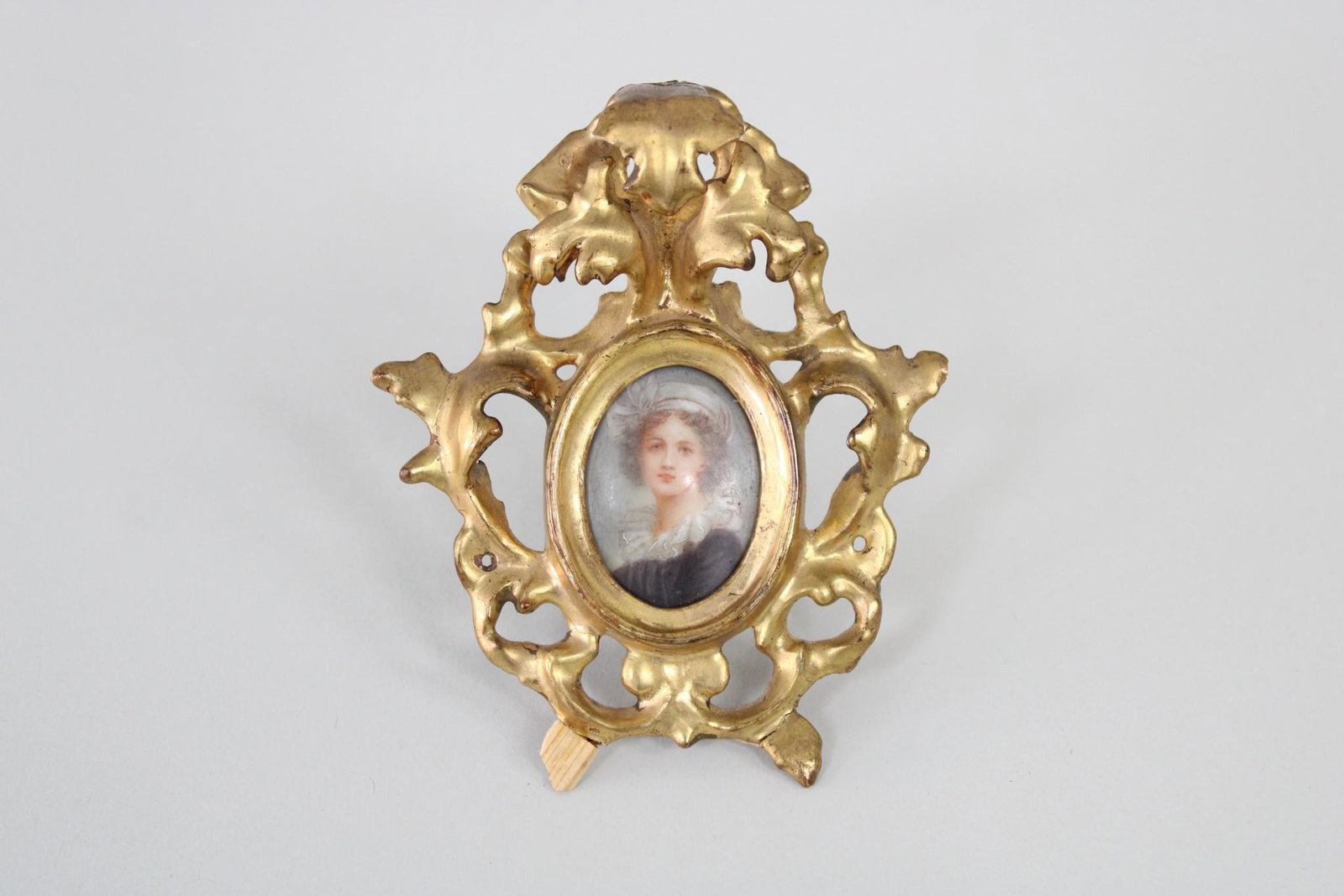 Miniature Painted Portrait of Woman in Gilt Frame: Miniature Painted Portrait of Woman in Gilt Frame. This is a beautiful miniature painting of a woman in an ornate gold gilt frame. The frame is just as beautiful as the intimate portrait. Labeled on t