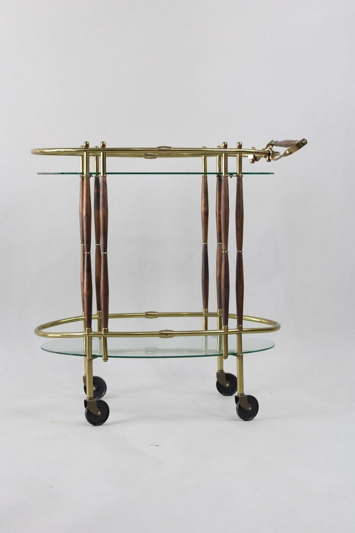 Mid Century Modern Brass & Walnut Oval Bar Serving Cart: Mid Century Modern Brass & Walnut Oval Bar Serving Cart. This rolling cart has a Danish and Hollywood Regency style to it. Dimensions are 32.75 in h x 17 in w x 31.5 in d. Condition is very good. Plea