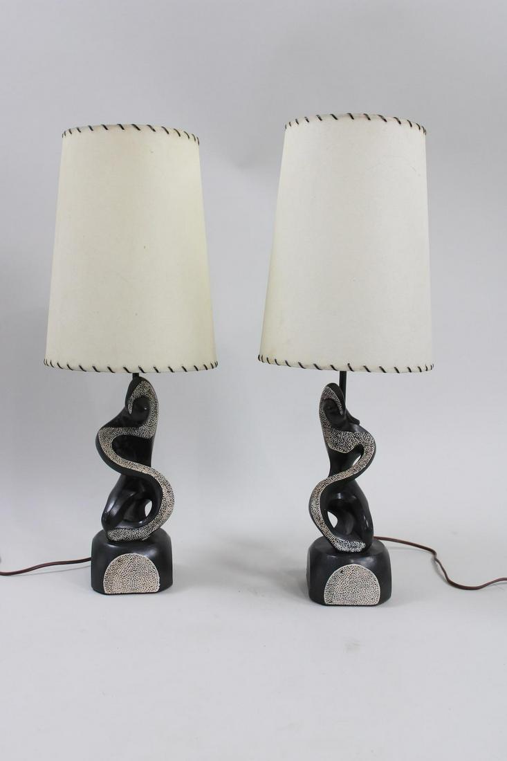 Pair of Mid-Century Modern Chalkware Black Lamps, Frederic Weinberg style: Pair of Mid-Century Modern Chalkware Black Lamps, in the style of Frederic Weinberg or Marianna Von Allesch. Black chalkware bases have abstracted human seated figures, with white shades trimmed in bl
