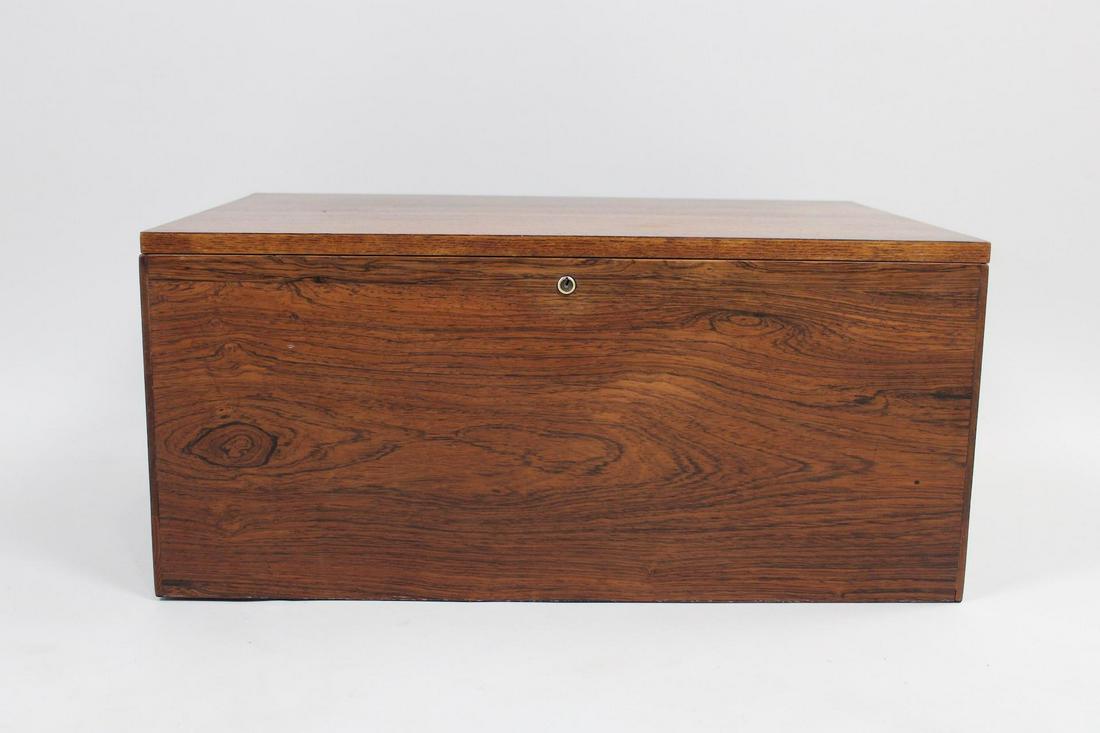 Mid-Century Modern Rosewood Lidded Storage Box: Mid-Century Modern Rosewood Lidded Storage Box. Sizable Scandinavian style box has a lid with brass hinges, and a small hole through one side. It has a lock but no key. Bottom appears to be pine. Dime