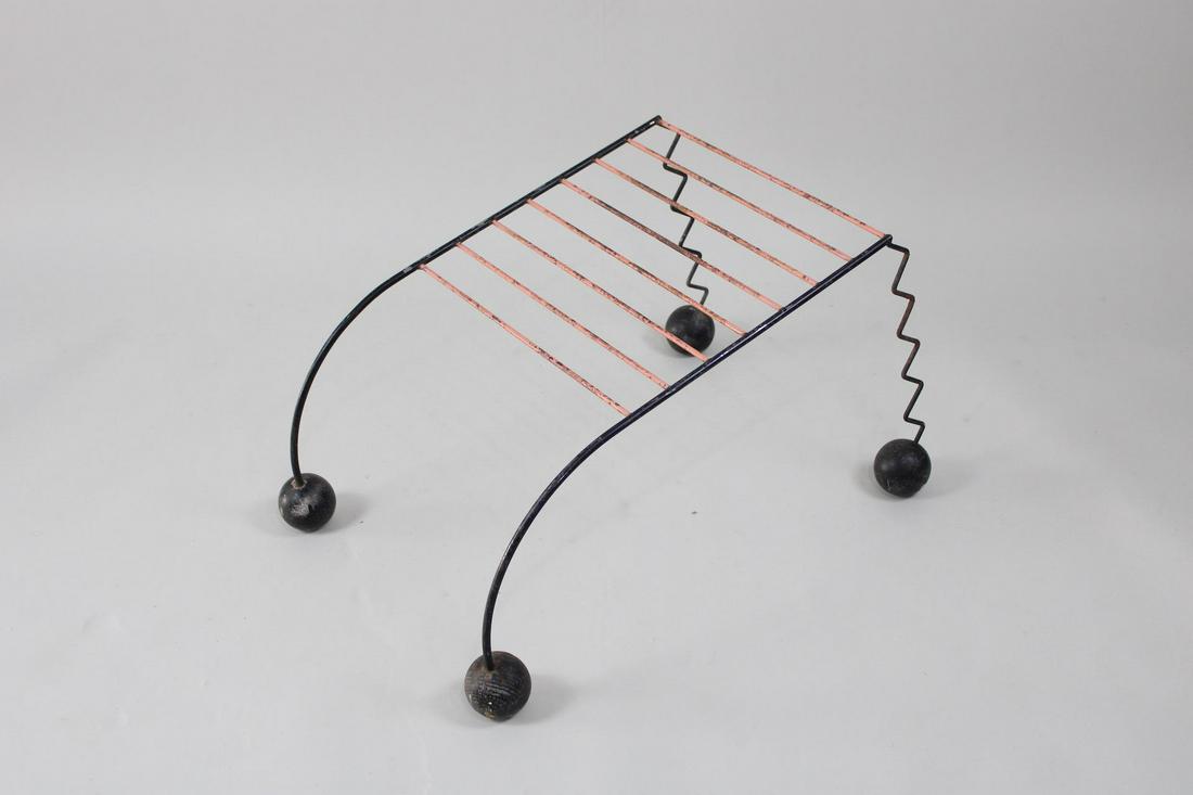 Postmodern Memphis Style Magazine Rack: Postmodern Memphis Style Magazine Rack. This magazine rack of wire and wooden ball shaped feet is very unique. The magazines would hang over a rod as shown. Dimensions are 16.25 in h x 19.75 in w x 28