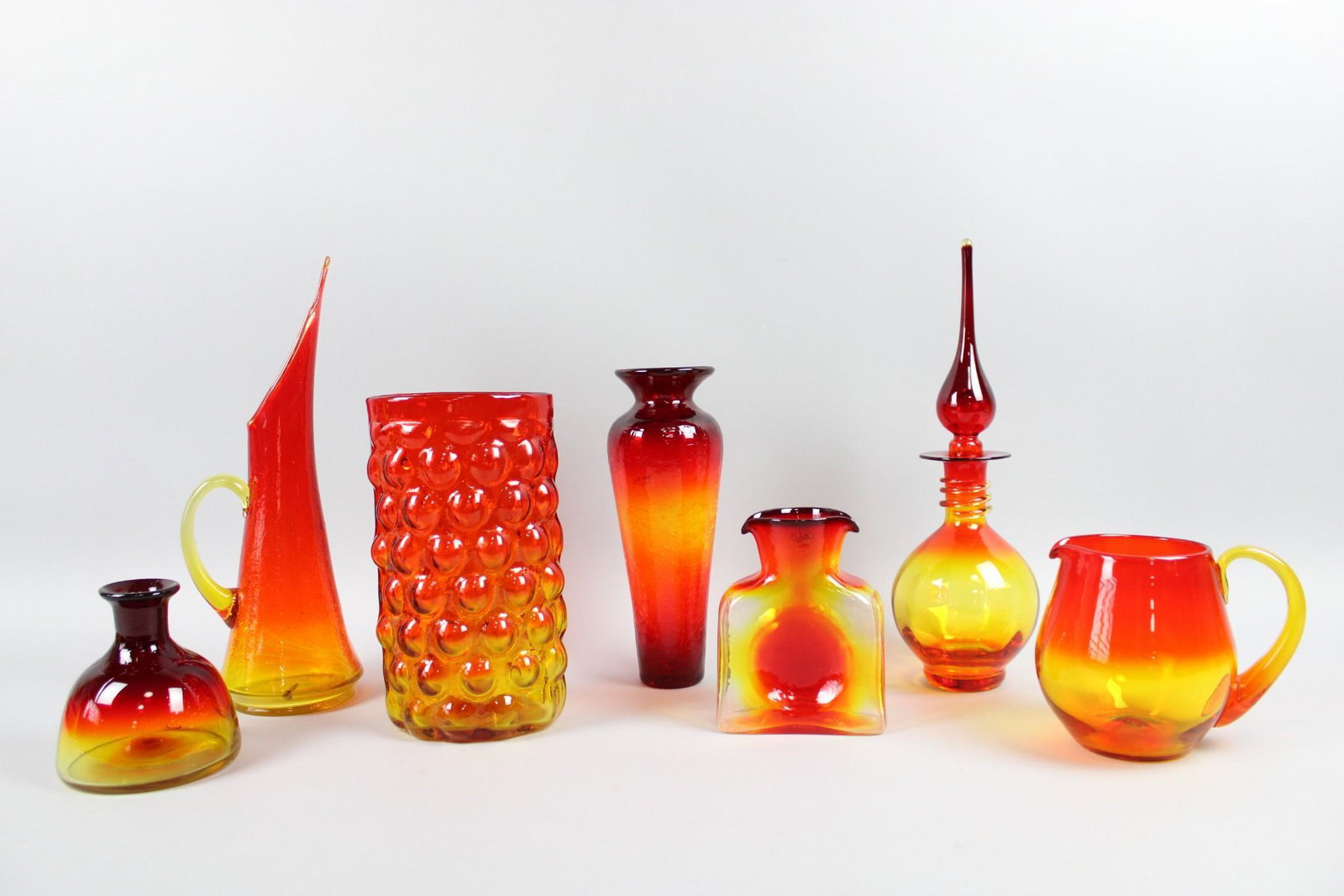Lot of 8 Mid-Century Modern Orange Ombre Art Glass, Blenko: Lot of 8 Mid-Century Modern Orange Ombre Art Glass, Blenko. Striking and colorful lot includes 8 vessels in red & orange ombre. One piece is marked Blenko. Dimensions are 5.5 in h x 5.5 in w x 6.75 in