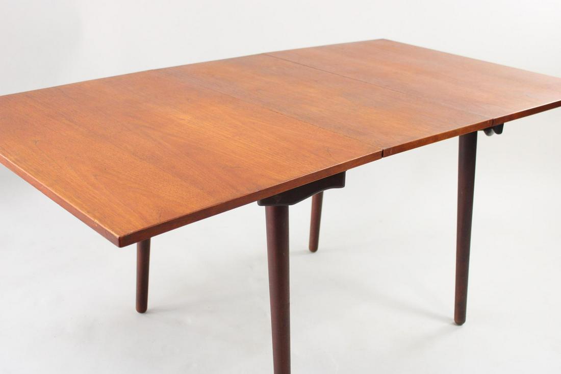 Mid-Century Modern Teak Double Drop Leaf Dining Table: Mid-Century Modern Teak Double Drop Leaf Dining Table. Scandinavian style table has 2 large leaves supported by swivel legs. Dimensions are 28.75 in h x 63 in w (extended) x 33.75 in d. Folded, width 