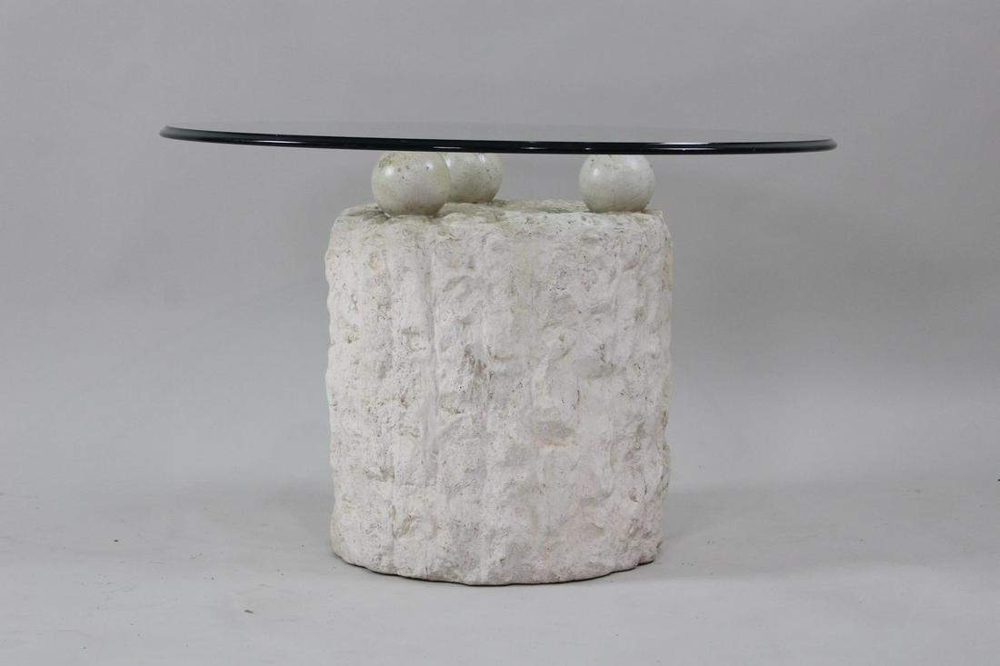 Postmodern Faux Mactan Stone Side Table: Postmodern Faux Mactan Stone Side Table. This is a ceramic faux stone postmodern base with glass top. Dimensions are 20 in h x 32 in w x 32 in d. Condition is very good. Please call or email for a det
