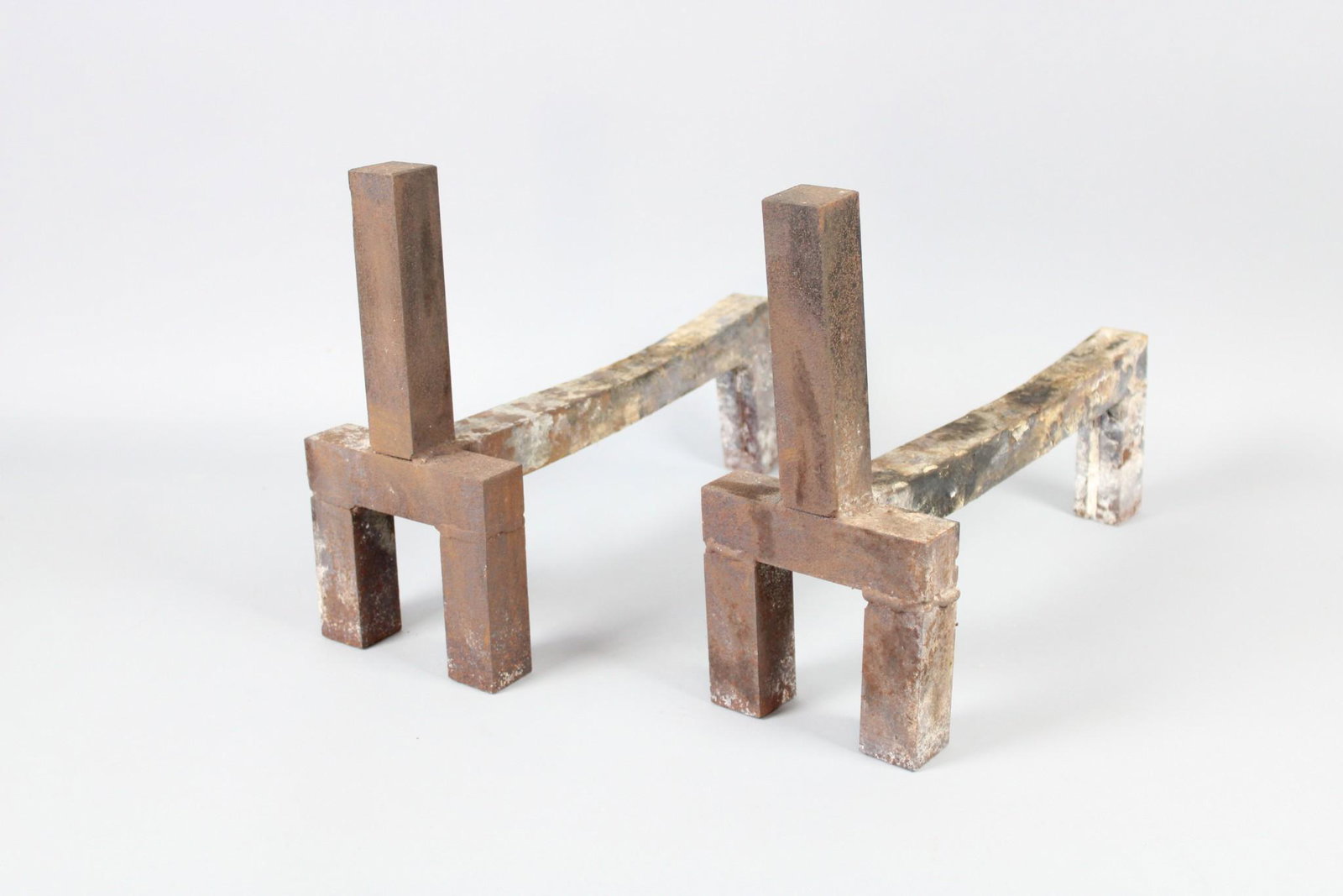 Pair of Modern Brutalist Cast Iron Andirons: Pair of Modern Brutalist Cast Iron Andirons. Striking pair of andirons made of cast iron bars welded together. Great patina. Dimensions are 12.75 in h x 6 in w x 16.5 in d. Condition is good with wear