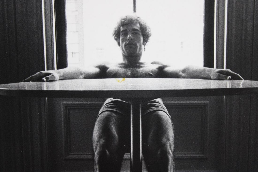George Stavrinos Photographs; Artistic Nude Couple in Studio: George Stavrinos, American Photographer 1948 - August 3, 1990. 2 nude photographs of a a couple posing with a mirror and man at table. These photos are undated but are from 1968-1983. Quantity: 2 Size