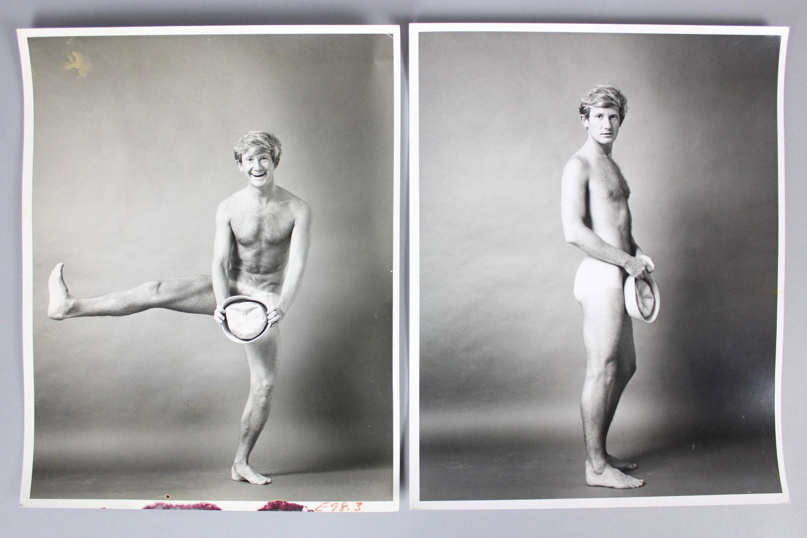 Kenn Duncan Photographs; Nude Men, Gay Interest: Kenn Duncan American Photographer 1928-1986. Lot of 10 B&W photos of nude men in various poses, some provocative and others humorous, such as the blonde holding the sailor hat, which was the cover of 
