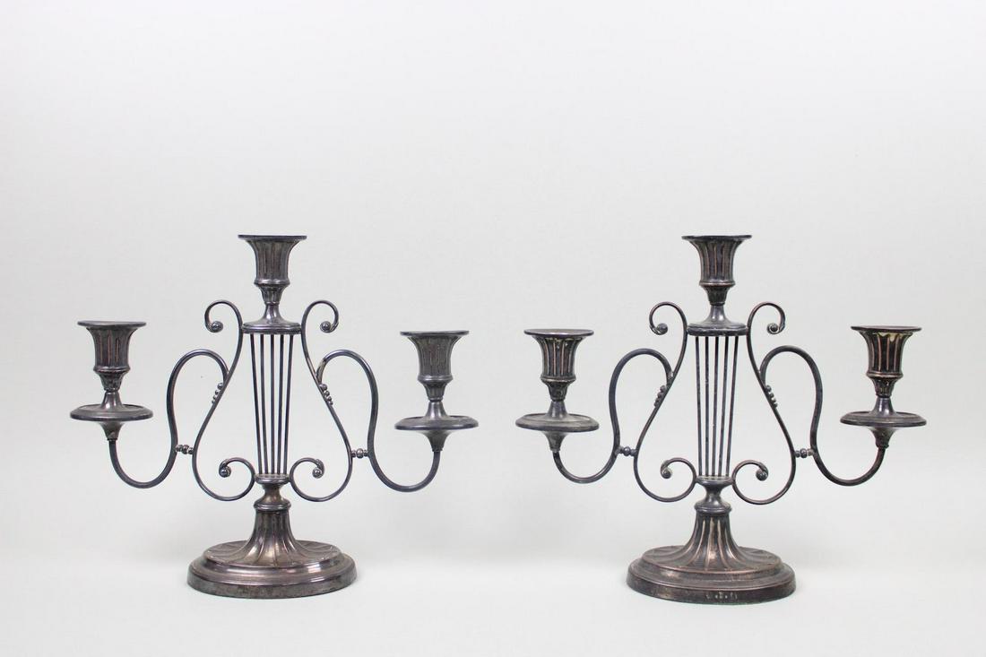 Pair of British Metal Lyre Design Candelabras: Pair of British Metal Lyre Design Candelabras. This is a handsome pair of metal candelabras. They have a lyre motif and each has three symmetrical holders. There are stamps in the metal on the base. T