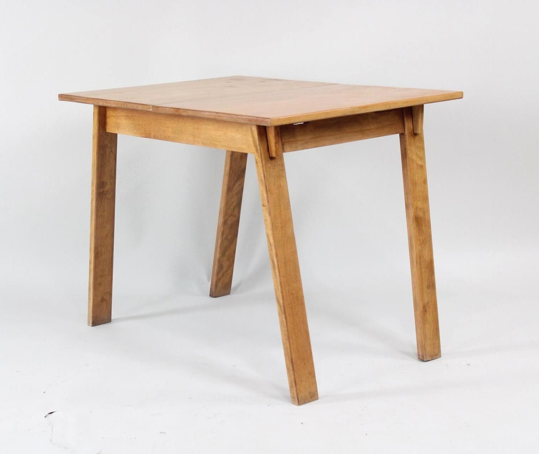 Mid-Century American Modern Russel Wright Dining Table, Minimalist, Conant Ball: Mid-Century American Modern Russel Wright Dining Table, Minimalist. This simple wooden table has angled legs and two leaves that slide together for the tabletop. Marked by stamp underneath as designed