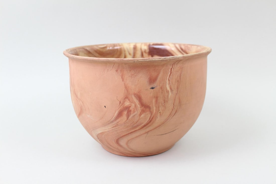 Marbled Swirl Ceramic Bowl, Planter: Tall Pink Marbled Clay Bowl, Planter. Glazed only on the inside, this pottery piece has a flat bottom and bulbous shape in a range of pink and red tones mixed with a cream colored marbling effect. Dim