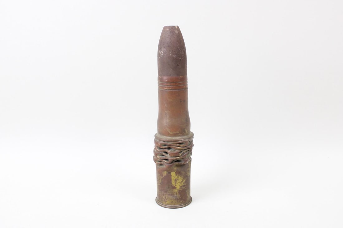 Trench Art Vase of Compressed Folded Bullet Shell: Trench Art Vase of Compressed Folded Bullet Shell. Tall and narrow, this vessel tapers at the top with a ridged molten grip towards the bottom. Marked underneath "W N.Y." and "1902" with other inscrib