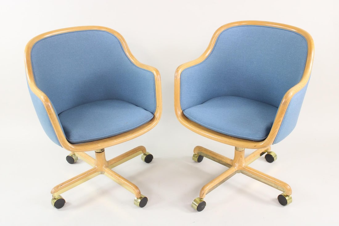 Pair of Ward Bennett Blue Wood & Brass Executive Chairs, Brickel: Pair of Ward Bennett Blue Wood & Brass Executive Chairs, Brickel. These two armchairs have wooden frames and polished brass accents on the four wheeled legs, with a blue colored fabric upholstery to t